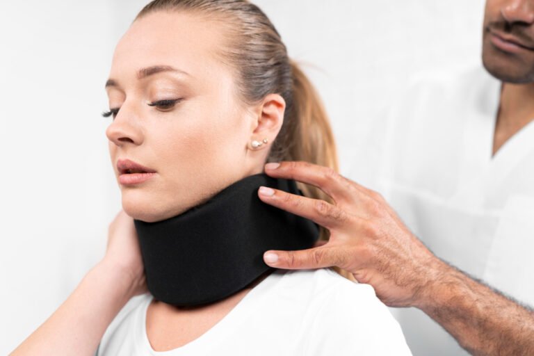 A woman in a neck brace is receiving assistance from a healthcare provider.